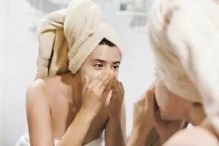 Женщина отшелушивает лицо Женщина отшелушивает лицо